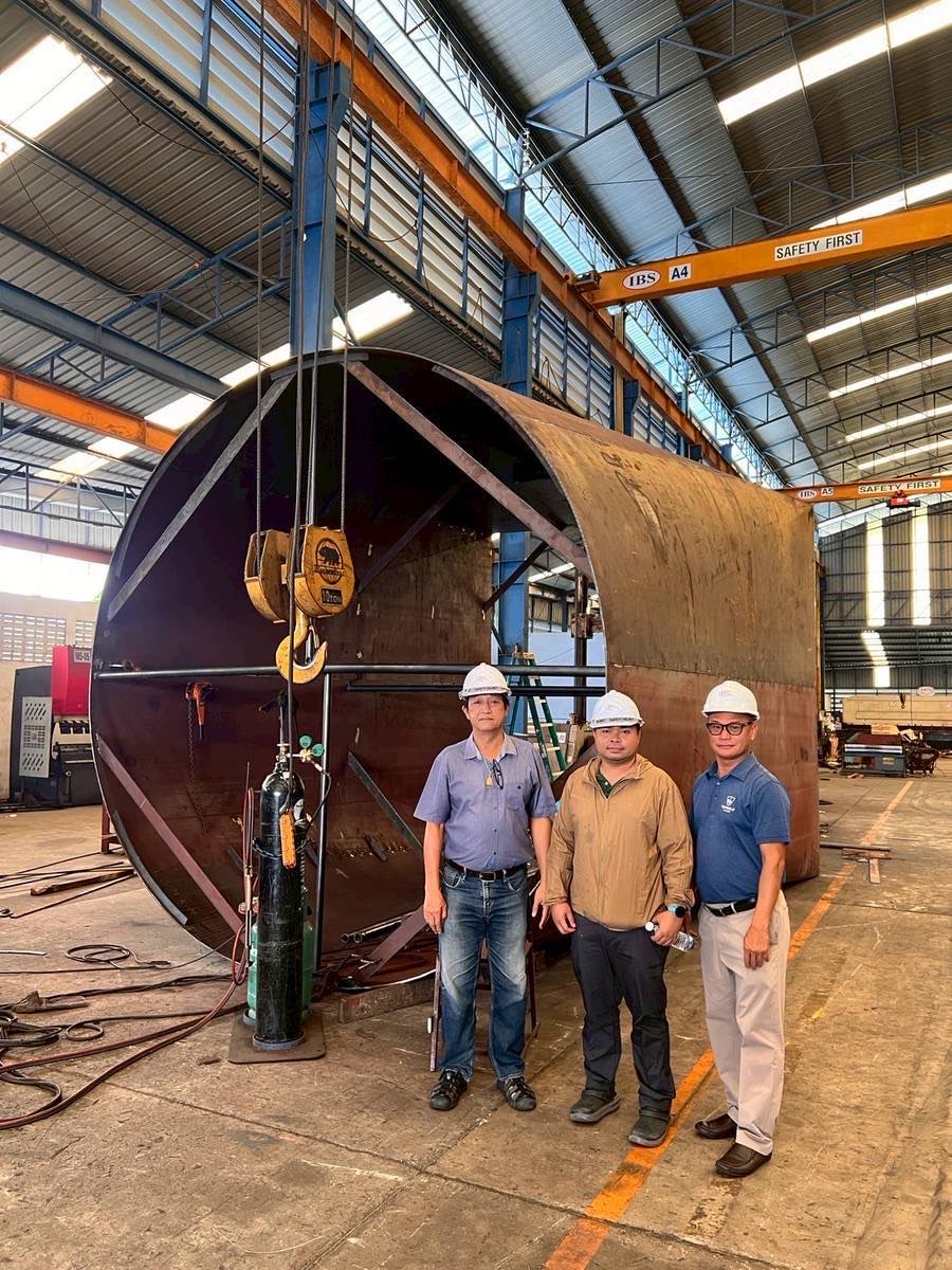 Phenovate team with a large cylindrical tank shell under the workshop crane
